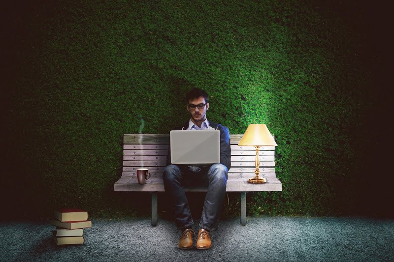 Man working on laptop in the shadows