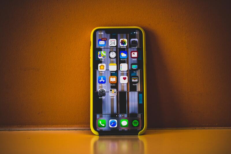 How to Locate M-PESA Menu on iPhone iPhone X against a wall