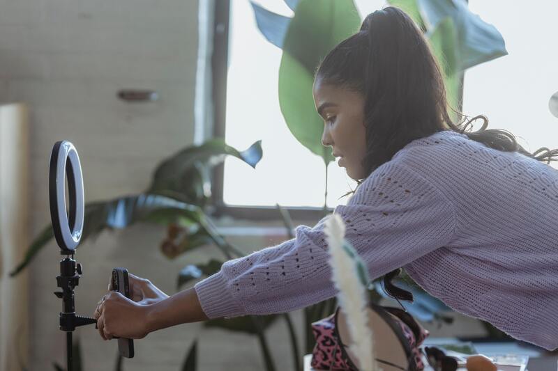 Woman setting up a phone camera for video shooting