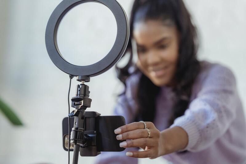 Black woman setting up a phone to record a video