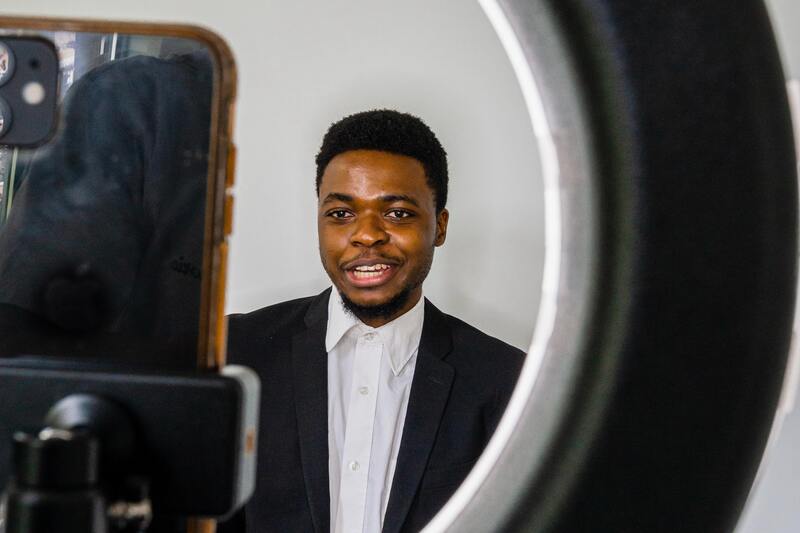 Man shooting a video on a phone and ring light