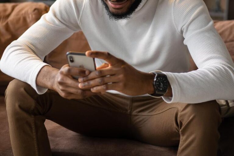 Sitted man texting on an iPhone