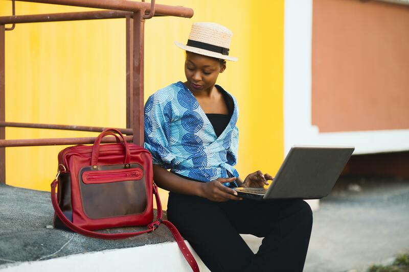 Woman with a travel bag and a laptop