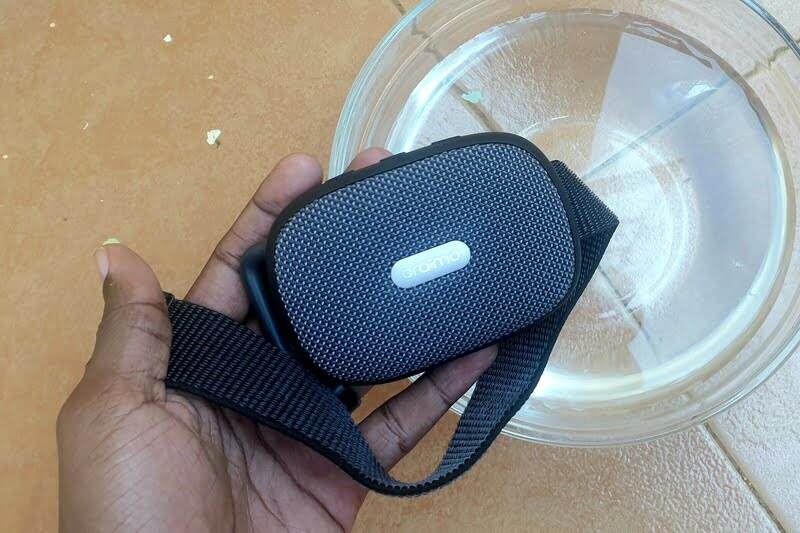 Man holding a portable speaker over a bowl of water